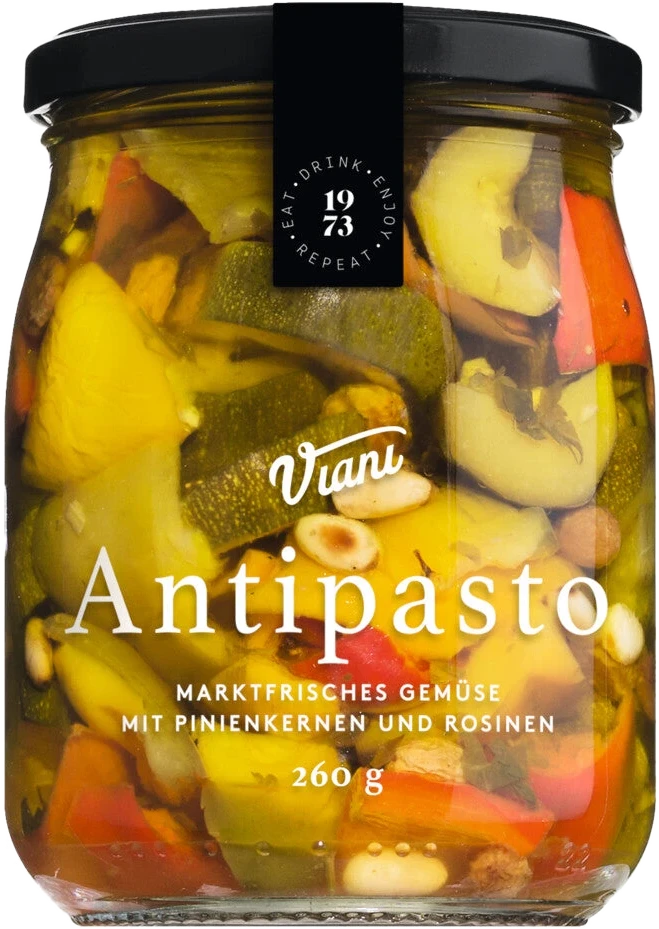 Glas mit Zucchini, roter und gelber Paprika, Pinienkernen und Rosinen in Öl. Antipasto Gemischtes Gemüse in Öl.