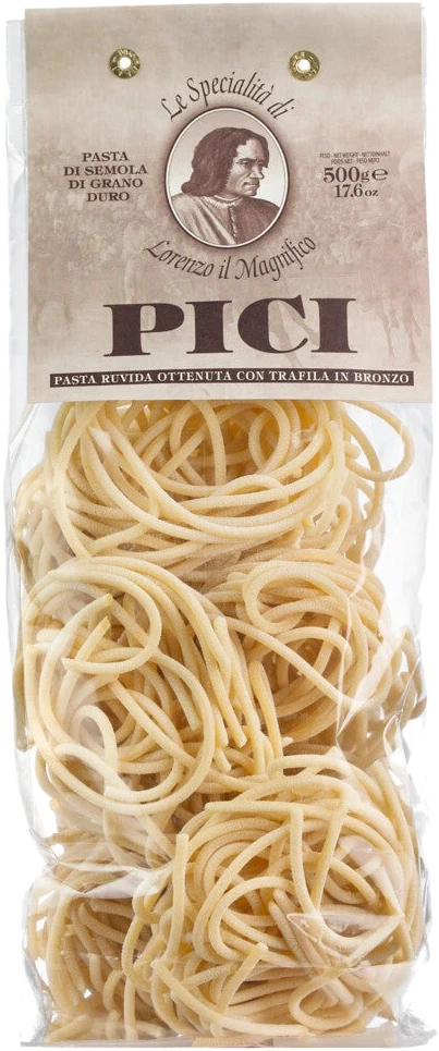 Pici – handgerollte toskanische Spaghetti aus Hartweizengrieß mit rauer Oberfläche, ungekocht auf Holzuntergrund
