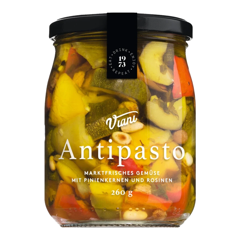 Glas mit Zucchini, roter und gelber Paprika, Pinienkernen und Rosinen in Öl. Antipasto Gemischtes Gemüse in Öl.