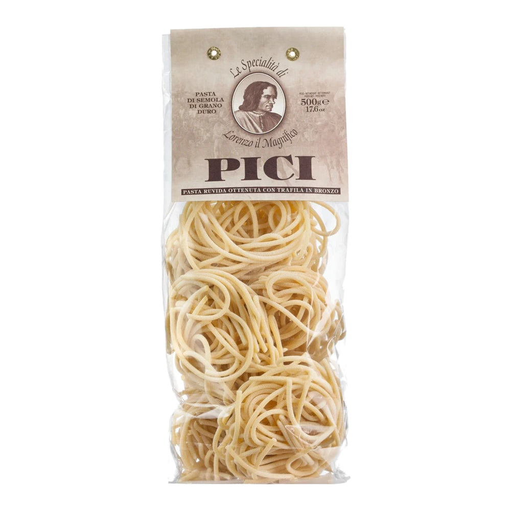 Pici – hand-rolled Tuscan spaghetti made from durum wheat semolina with a rough surface, uncooked on a wooden background