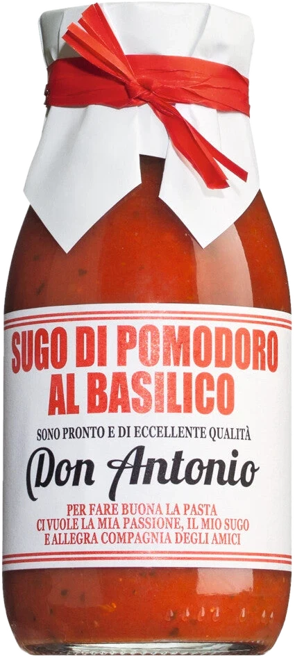 Glas Sugo al basilico mit Tomaten und Basilikum auf hellem Untergrund
