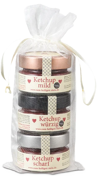 Zum Heiligen Stein Ketchup Sortenmix, drei Glasflaschen à 750 g, nebeneinander auf hellem Untergrund